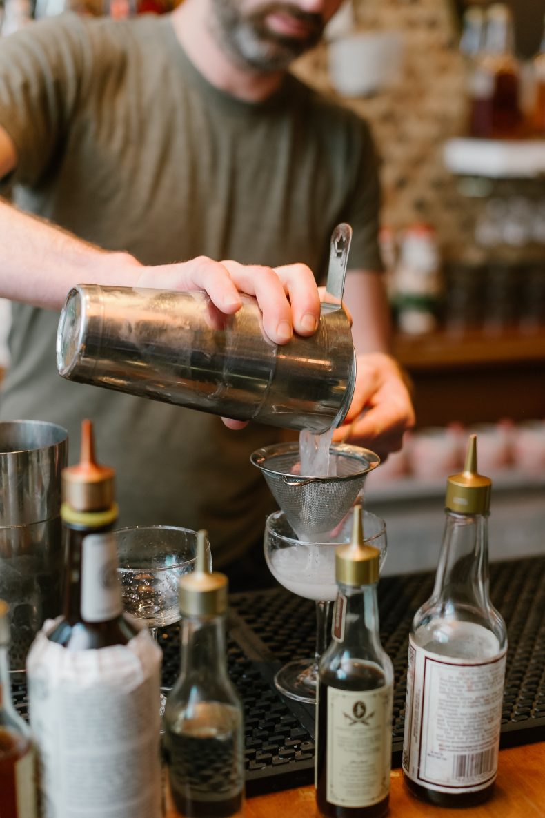 Bartender straining a cocktail